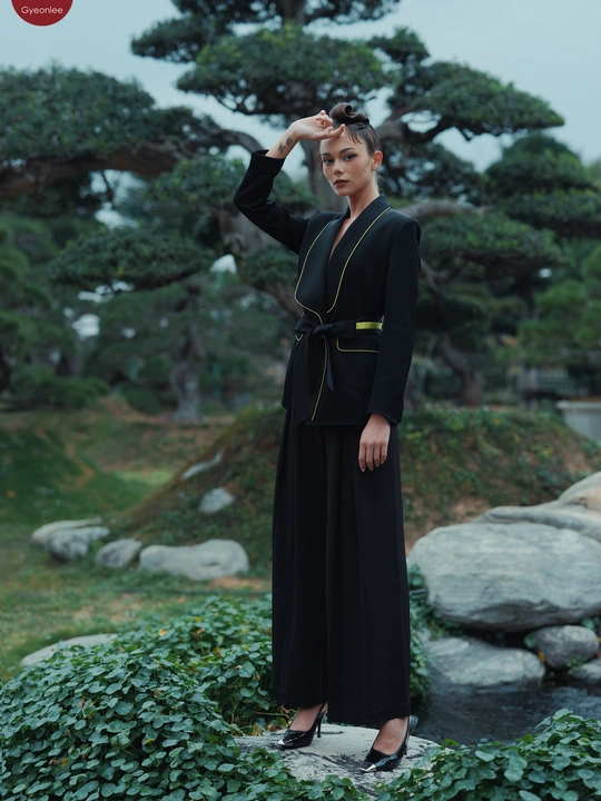 一位穿着黑色连衣裙的女士站在花园里