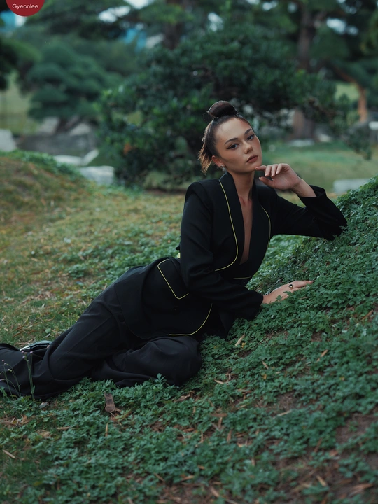 一位全黑衣女子在绿草地上摆姿势