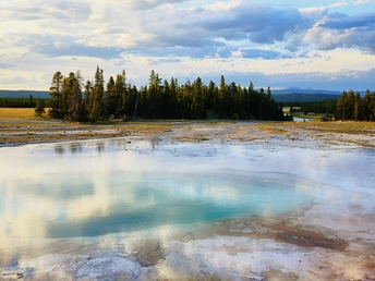背景中有树木和山脉的蓝色游泳池