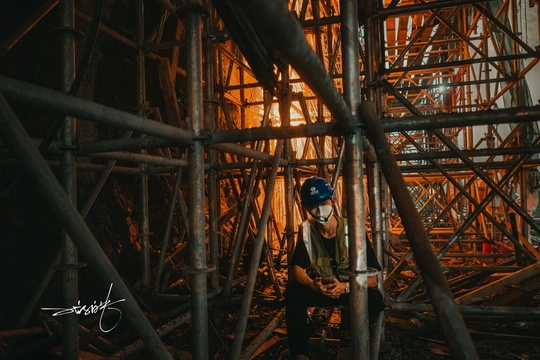 站在脚手架上的建筑物在建工程中的男子 夜晚