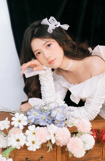 一个穿着白色连衣裙的漂亮年轻女子在胸前摆姿势