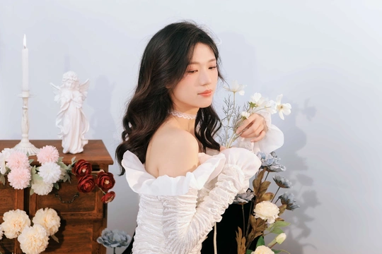 一个穿着白色连衣裙、肩上有白花的女人