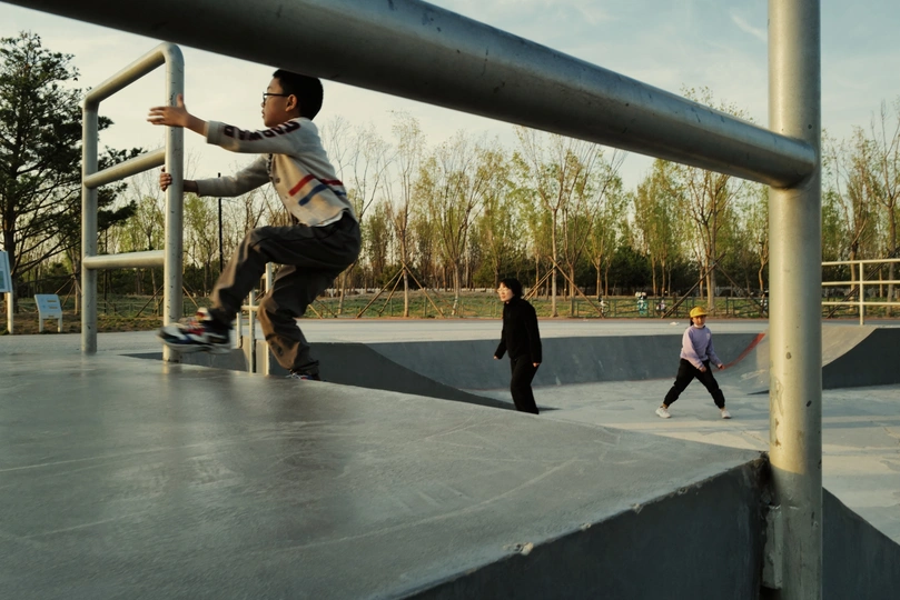 一个年轻人在滑板公园的斜坡上滑板 其他孩子在斜坡上滑板。