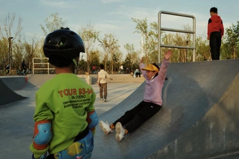 一个年轻男孩和一个小女孩在滑板公园骑滑板