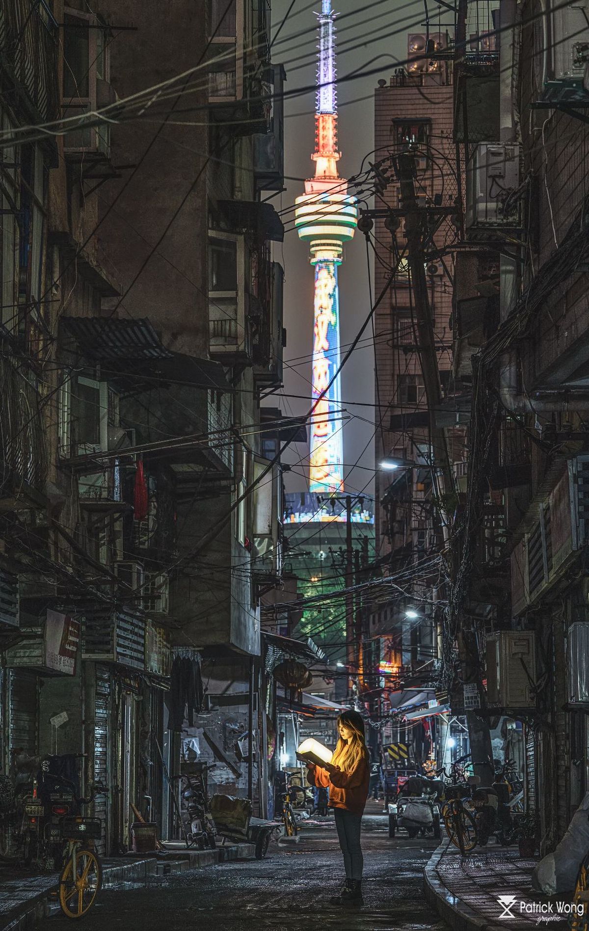 站在城市夜晚的一条小巷旁边 一座高塔的男子
