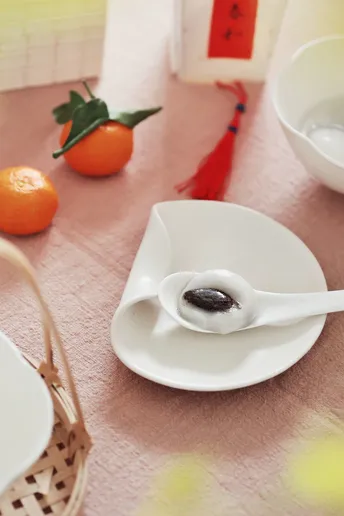 一个带有橙子的桌子 一个带有勺子和食物的白色盘子