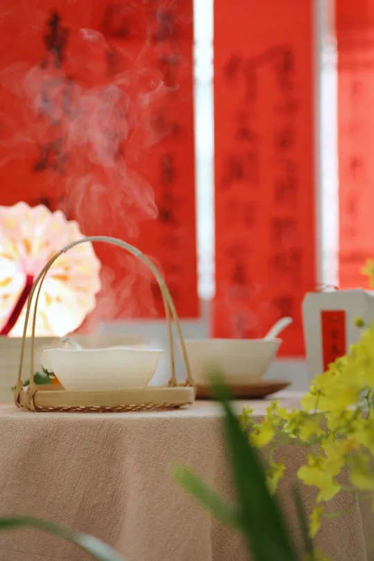 一个带有食物的桌子 一个装满热茶的杯子 茶杯中冒出烟雾。