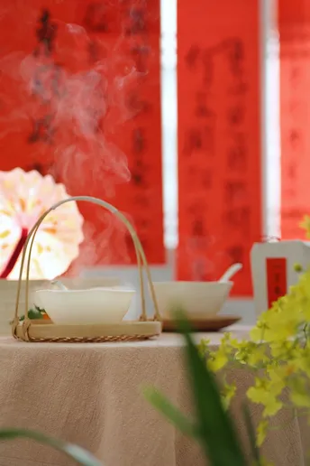 一个带有食物的桌子 一个装满热茶的杯子 茶杯中冒出烟雾。