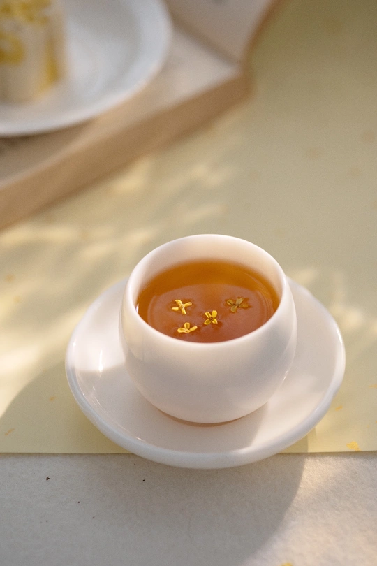 一小碗汤放在一个白盘子上 盘子放在托盘上