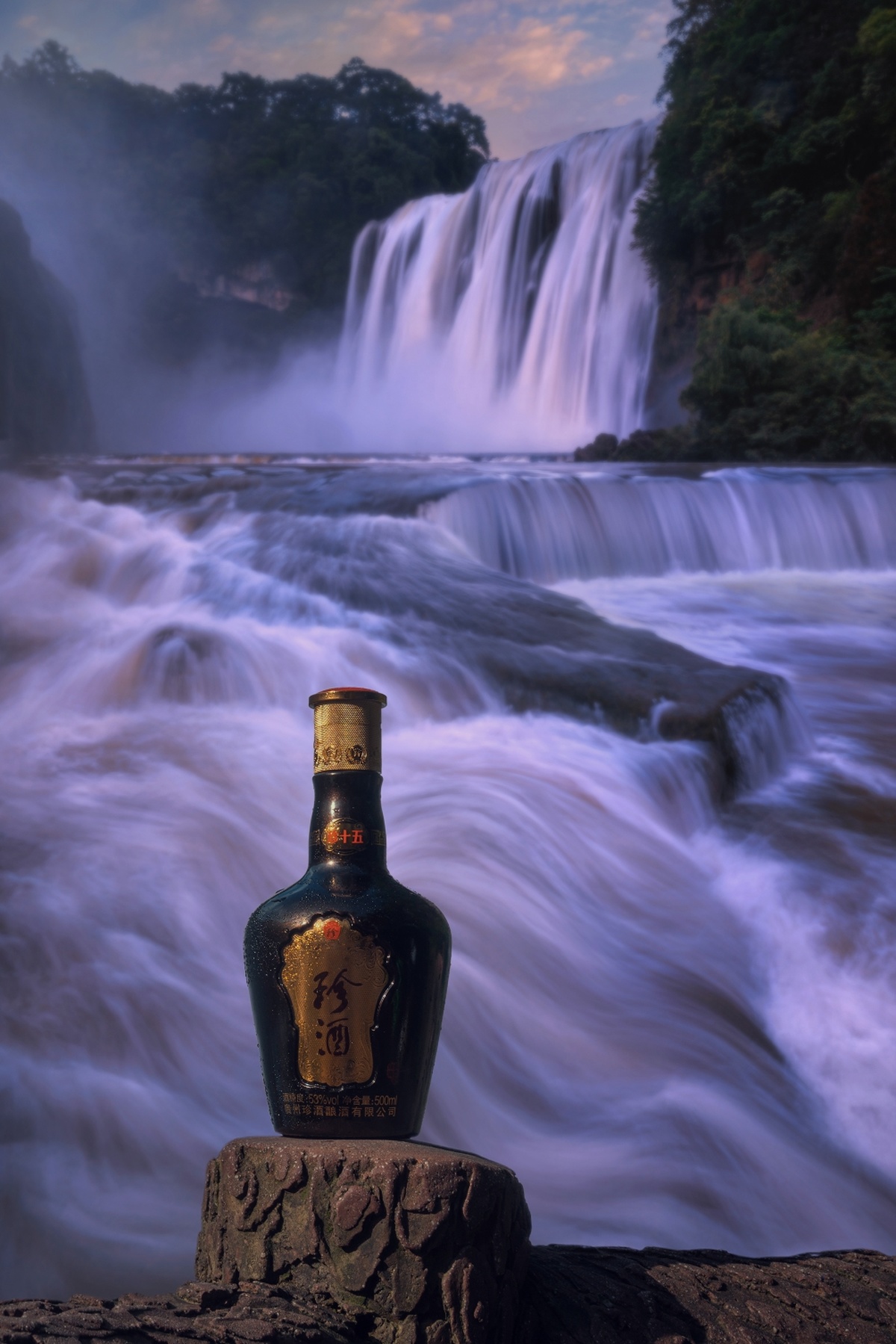 一个瓶子放在瀑布前的岩石上