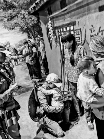 一张黑白照片 一位妇女抱着一个小孩子 一位男子抱着一个婴儿 沿着街道走。