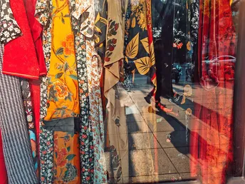 一家有彩色服装和领带挂满衣架的商店的窗户