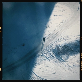 一个人在雪山上骑着滑雪板滑下 而另一个人站在雪板上。