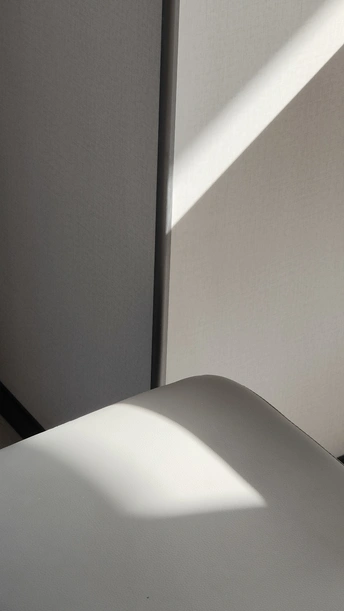 一个房间角落被阳光透过窗户照射 在墙上投下阴影。