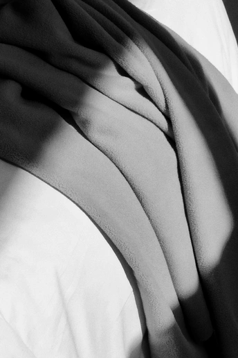 在一张带有白色床单和枕头的床上的人