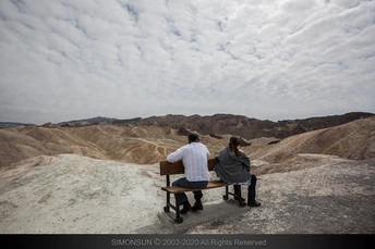 一些人在长凳上坐着 凝视着山丘和山脉的风景。