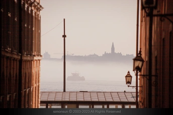 雾气缭绕的城市中有一艘大型船在水中。