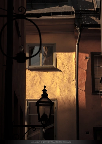 建筑物阴影和夜晚街灯照亮的一个时钟