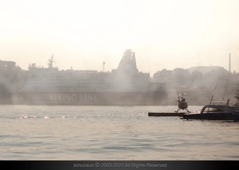 雾中远处有一个停泊着船的码头和一些船以及一个人