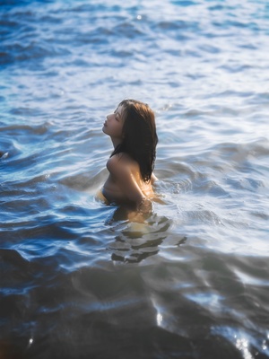 一个年轻女子在漂浮在海洋中的水体中游泳