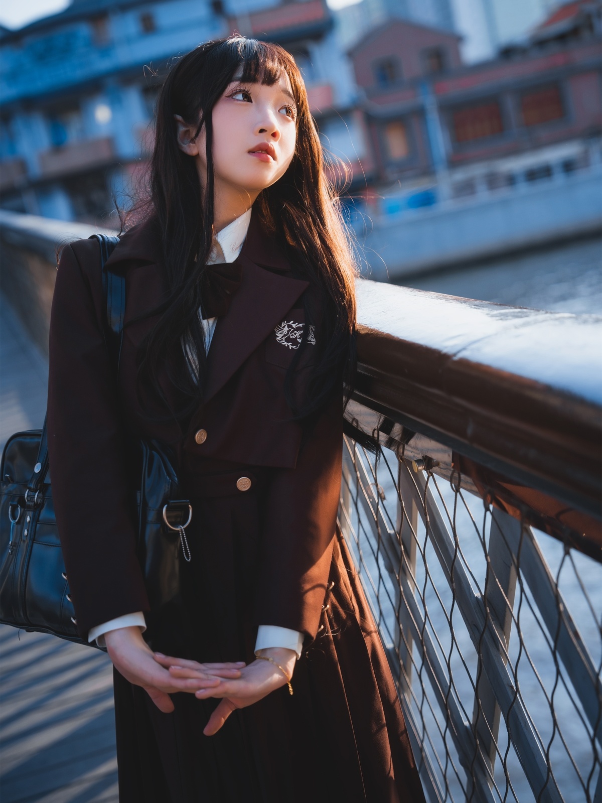 一个穿着黑色外套的年轻女子站在一座桥上