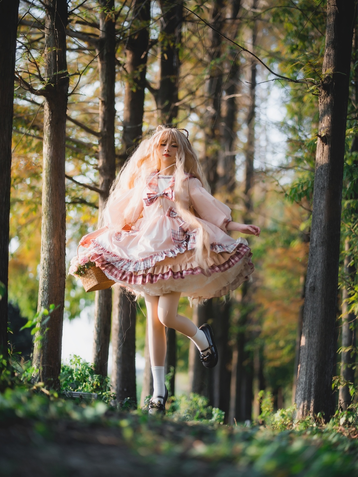 一个小女孩穿着粉红色裙子在森林里奔跑