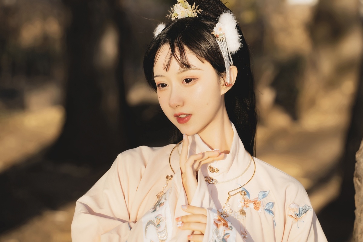 一位亚洲女性穿着传统的日本和服 身上披着一件带有花卉图案的白色的和服 