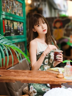 一个年轻女子坐在咖啡馆的桌子旁喝着茶。
