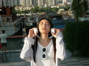 一个年轻女子戴着白色耳机听音乐