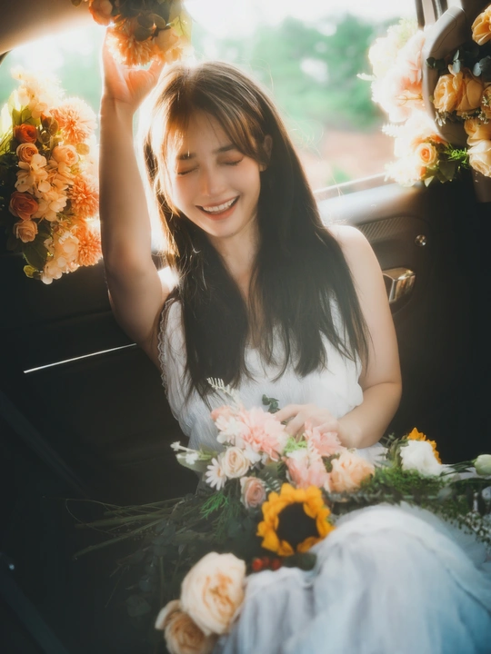 一位女性坐在汽车里拿着花