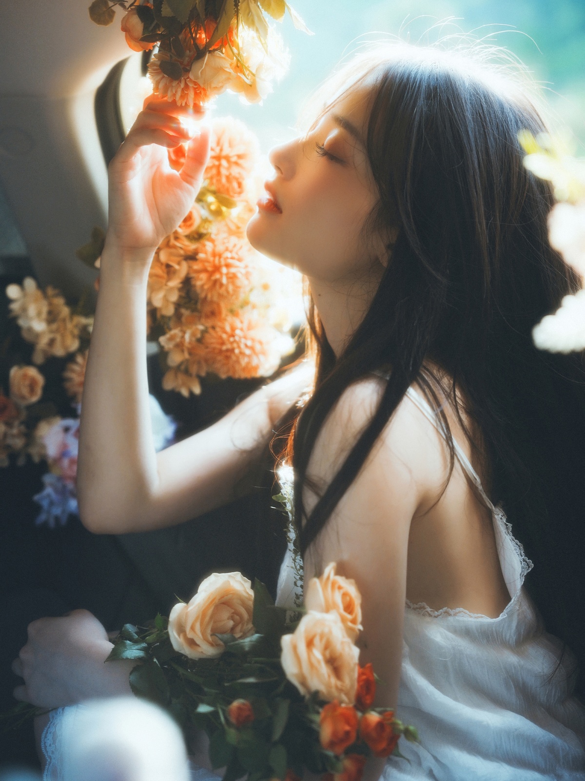 一个年轻女子坐在汽车里拿着花