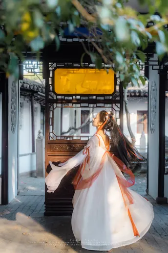 一个穿着白色连衣裙的美女走在街上