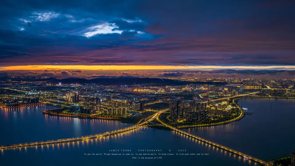 城市和岛屿在黄昏或日落时被照亮了的上空视角