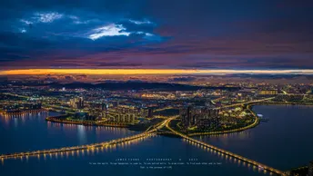 城市和岛屿在黄昏或日落时被照亮了的上空视角