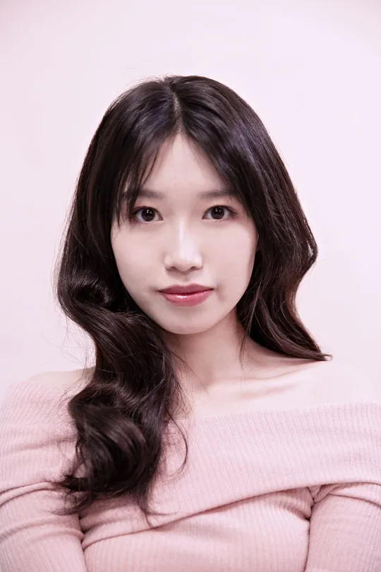 一位长发年轻女子穿着粉色毛衣的肖像