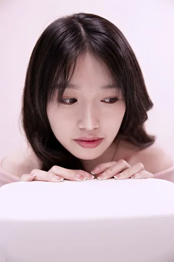 一位年轻女子坐在白色笔记本电脑前 脸上带着惊讶的表情。