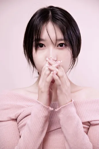 一个穿粉色毛衣的年轻女子用手捂住自己的脸