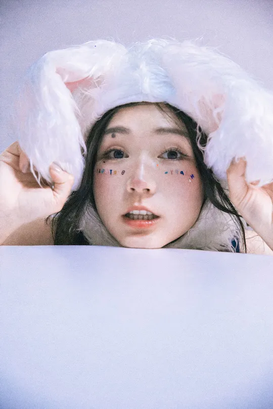 一个年轻女子躺在床上 脸上盖着白色布单。