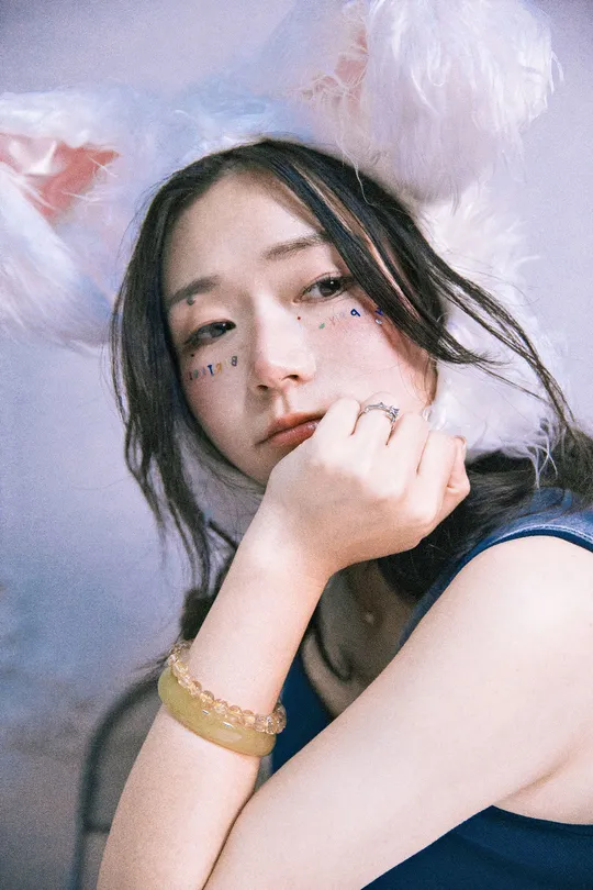 一位纹有纹身的年轻女子脸上戴着羽毛