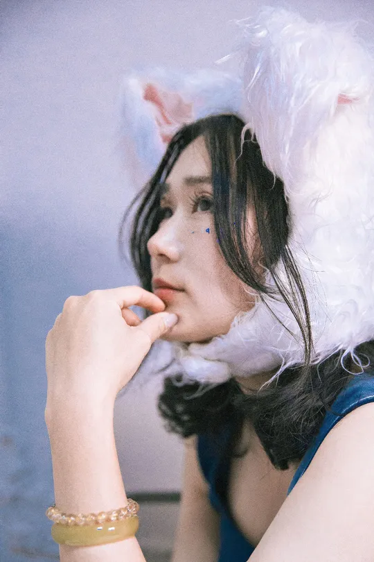 一位年轻女子戴着白色假发和蓝色连衣裙