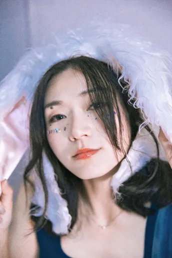 一位年轻女子戴着帽子 将脸颊靠近头部。