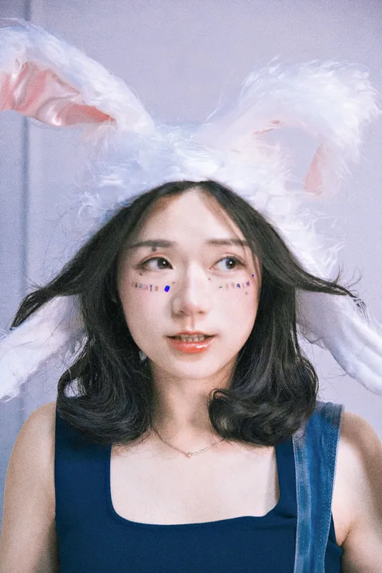 一位头戴兔子耳朵的帽子上的女士 脸上也带着一只兔子。