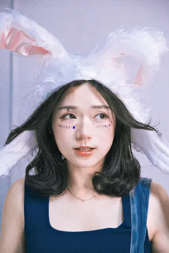 一位头戴兔子耳朵的帽子上的女士 脸上也带着一只兔子。