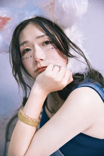 一位穿着蓝色连衣裙和脸上带羽毛帽子的年轻女子