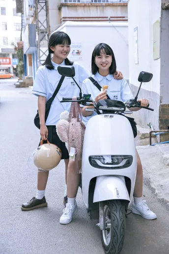 一些穿制服的年轻人坐在摩托车上在街上