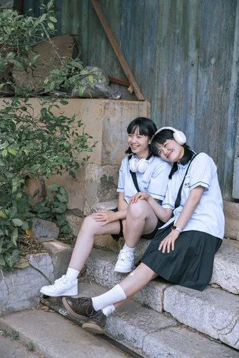 两个穿制服的女孩坐在一些台阶上
