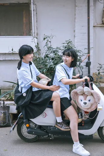 一些年轻人骑着滑板车 上面坐着一只泰迪熊 还有一辆摩托车。