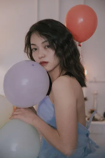 蓝色连衣裙的年轻女子拿着气球