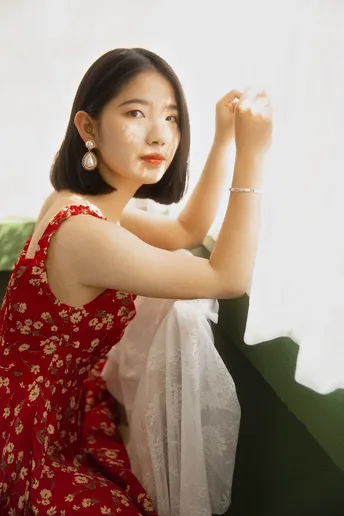一个穿着红裙子的年轻女子坐在沙发上