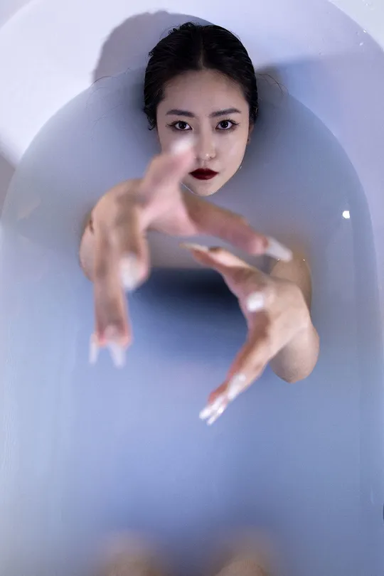 一个漂浮在浴缸里的女人 双手在水中
